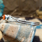 Sterling silver cuff bracelet with red spiny oyster shell set in a rounded-square bezel, framed by twisted rope accents.