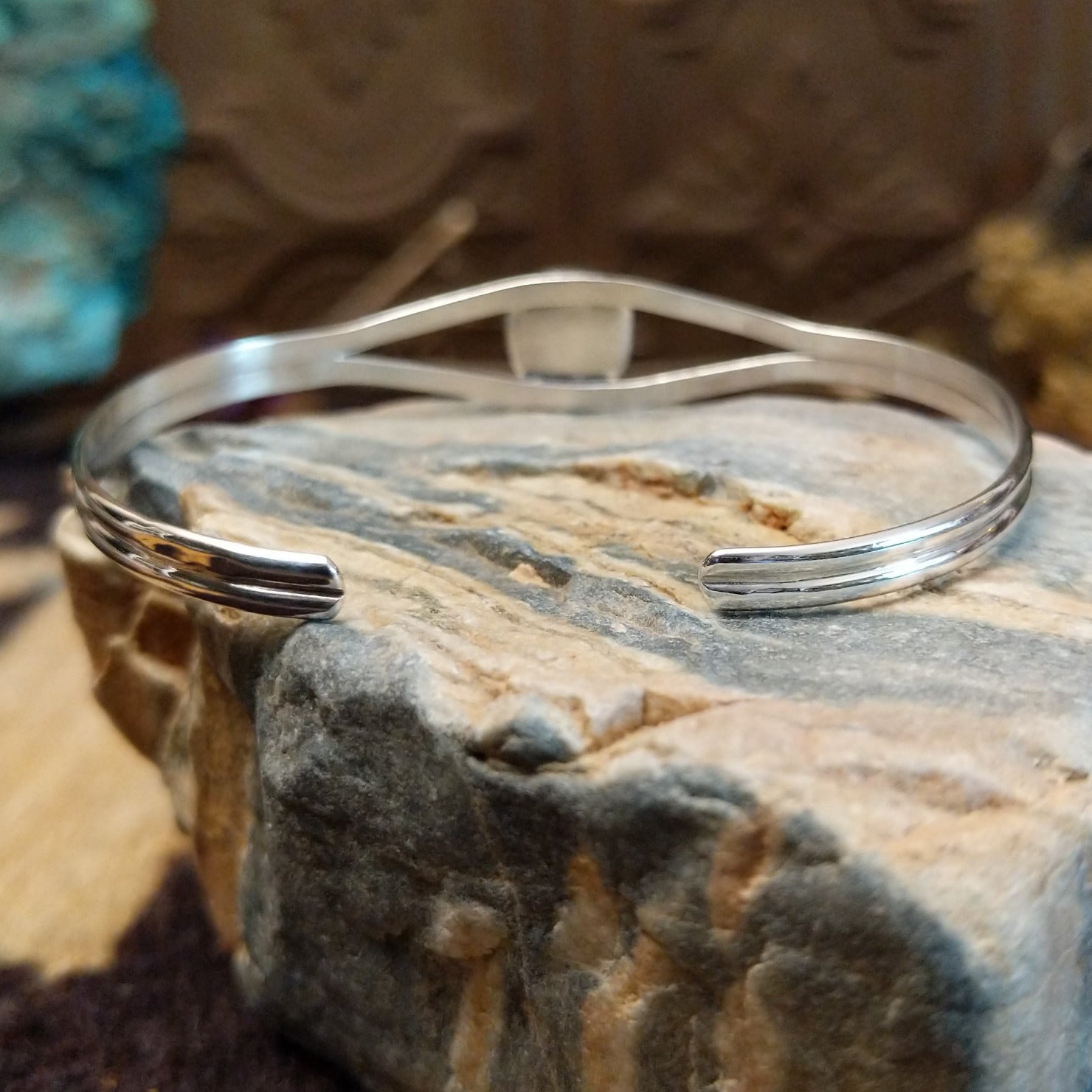 Sterling silver cuff bracelet with red spiny oyster shell set in a rounded-square bezel, framed by twisted rope accents.