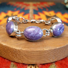 Sterling silver link bracelet with charoite set in oval bezels.