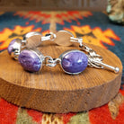 Sterling silver link bracelet with charoite set in oval bezels.