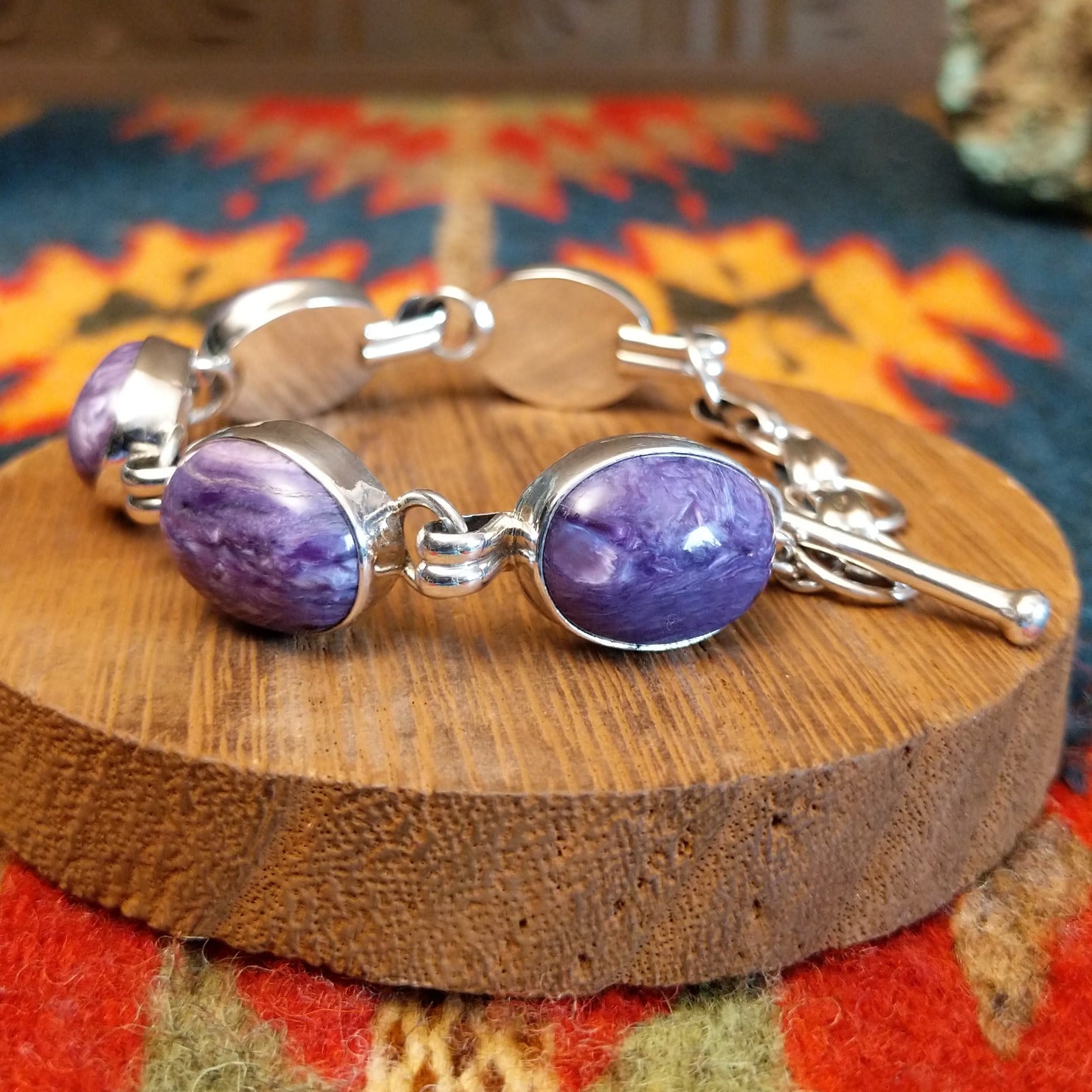 Sterling silver link bracelet with charoite set in oval bezels.