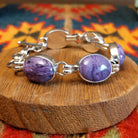 Sterling silver link bracelet with charoite set in oval bezels.