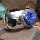 Sterling silver cuff featuring an oval charoite stone framed by a twisted rope bezel.
