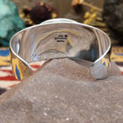 Sterling silver cuff featuring an oval charoite stone framed by a twisted rope bezel.