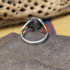 Charoite ring by Terry Wood, featuring a vibrant purple charoite stone with natural swirling patterns set in a handcrafted sterling silver band.  Underside view.