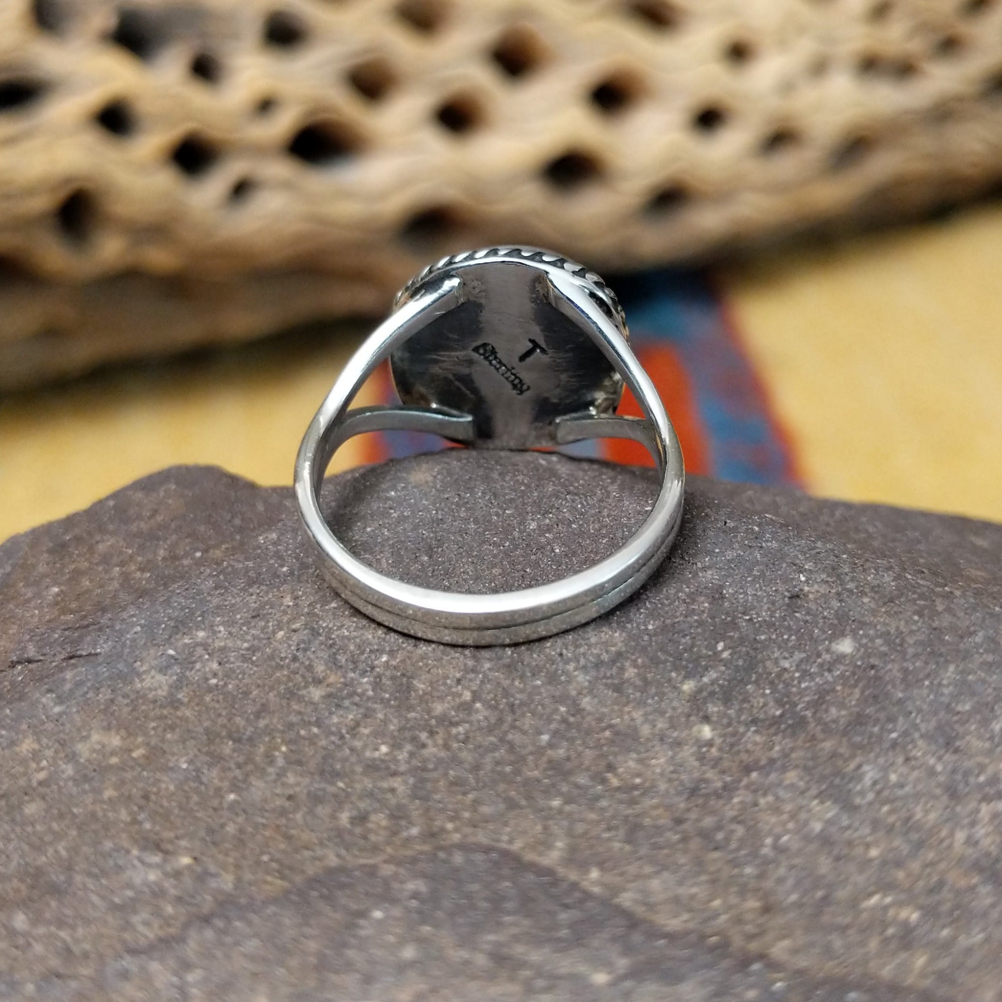 Charoite ring by Terry Wood, featuring a vibrant purple charoite stone with natural swirling patterns set in a handcrafted sterling silver band.  Underside view.