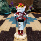 Mini chili pepper kachina by Rosalind Grey with yellow face, white fur collar, red body, and white geometric-patterned garment.