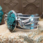 Sterling silver cuff bracelet with Chinese turquoise set in the large, oval bezel and feather silverwork on the band.