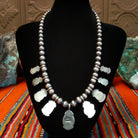 The smooth sterling silver bezels and beaded chain of the necklace.