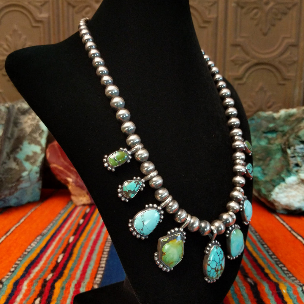 Chinese turquoise set in dotted bezels set along the sterling silver beaded chain.