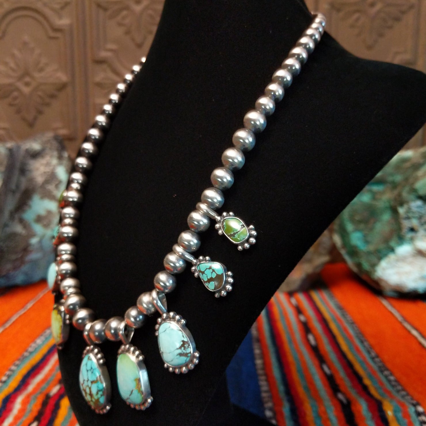 Chinese turquoise set in dotted bezels set along the sterling silver beaded chain.