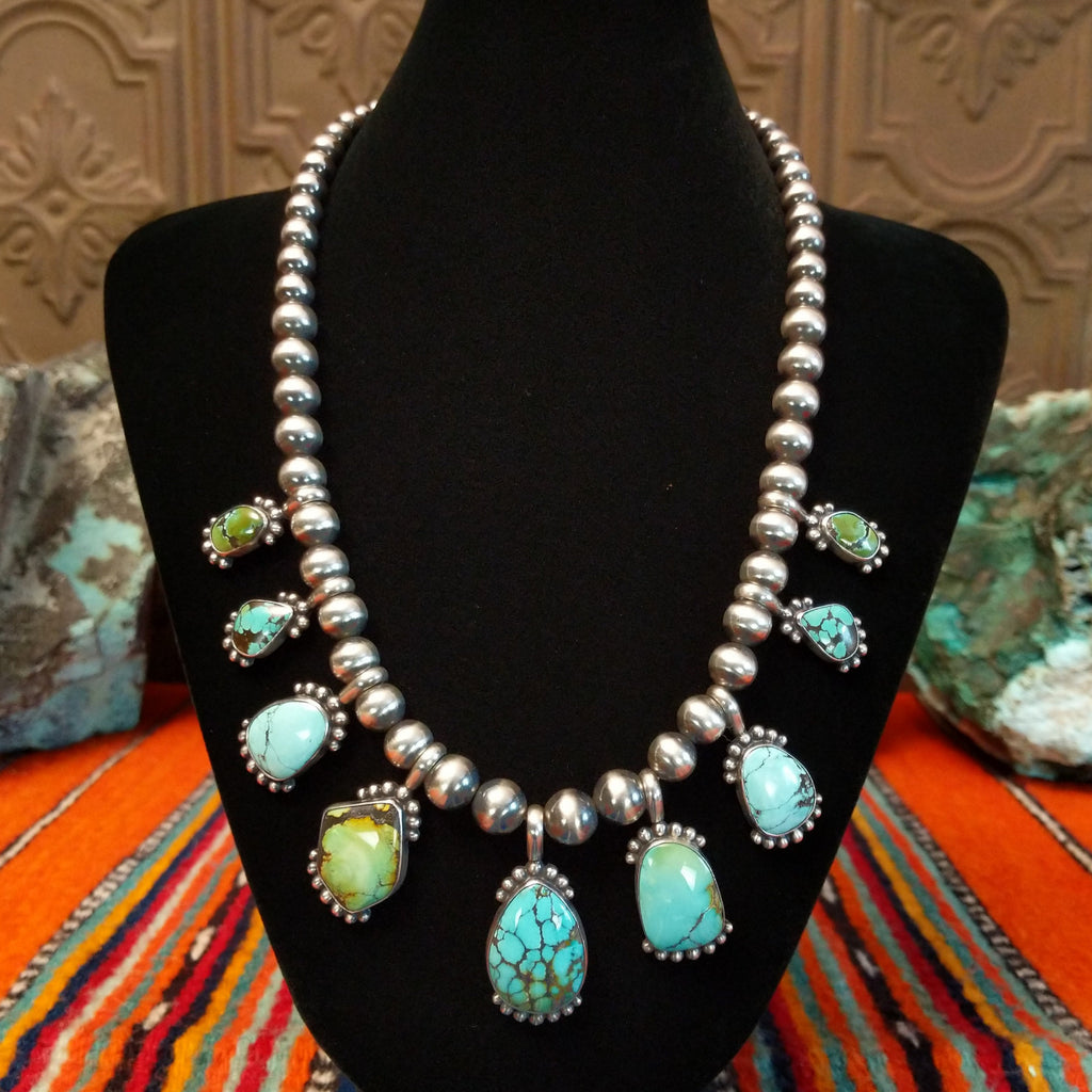 Chinese turquoise set in dotted bezels set along the sterling silver beaded chain.