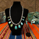 Chinese turquoise set in dotted bezels set along the sterling silver beaded chain with matching earrings.