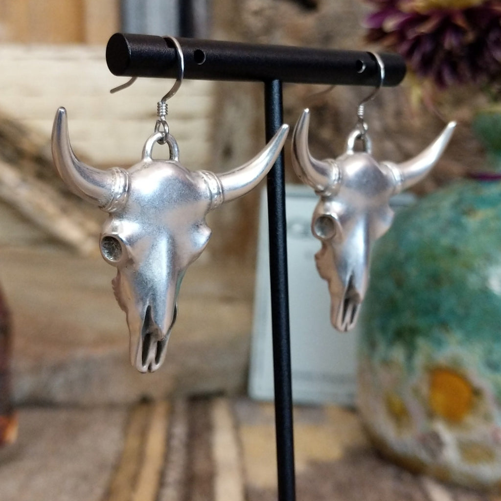 Metal bull skull dangle earrings with curved horns.