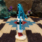 Mini clown kachina by Rosalind Grey with turquoise pigtails, white face, black striped body, and white geometric-patterned garment.