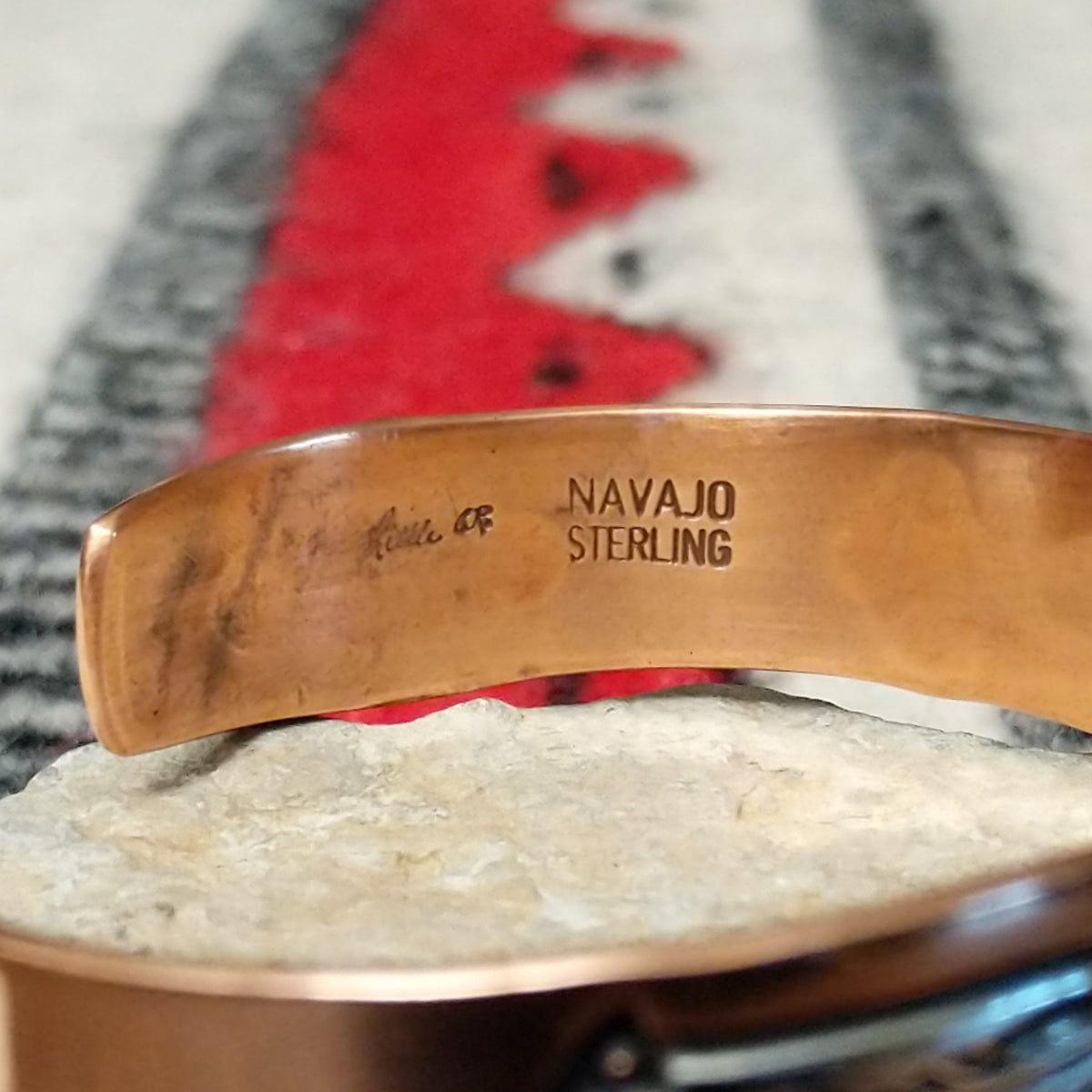 This Copper & Silver Feather Cuff by Robert Little features polished copper borders and a sterling silver center decorated with detailed feather motifs, curved accents, and dark oxidized stamping; artisan and Sterling Silver stamp.
