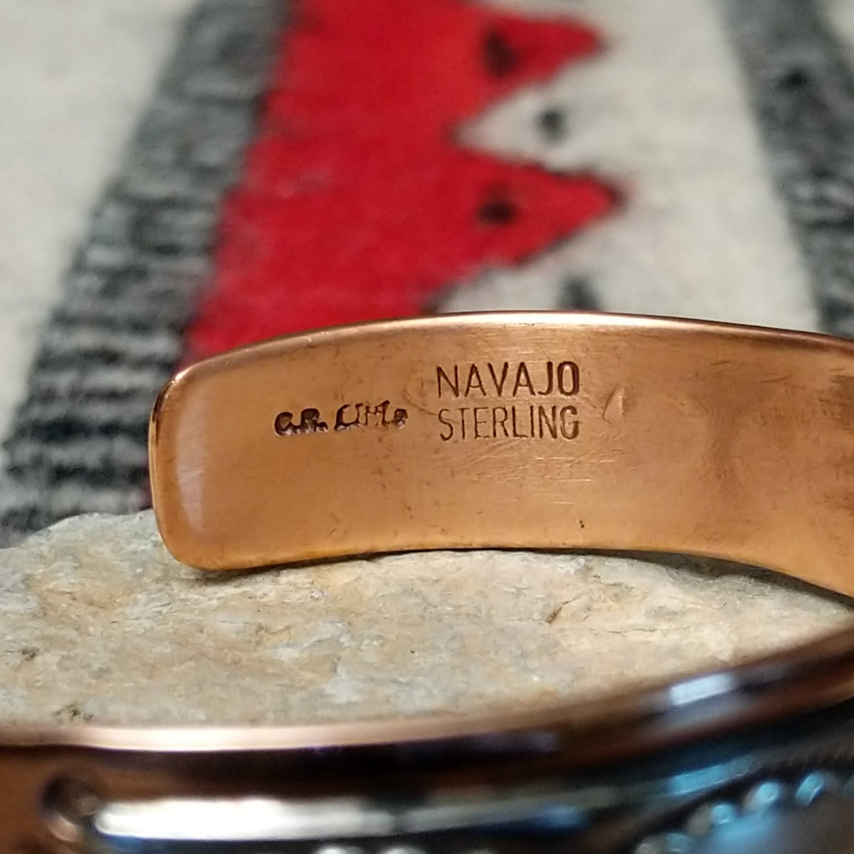 This Copper & Silver Cuff by Robert Little features polished copper borders, a sterling silver center, repeating scalloped hand-stamped motifs, fine textured edges, and dark oxidized accents; artisan and Sterling Silver stamp.