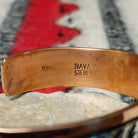 Copper and silver cuff by Robert Little featuring a repeating oxidized hand-stamped design across the silver center, framed by polished copper borders; artisan and Sterling Silver stamp.