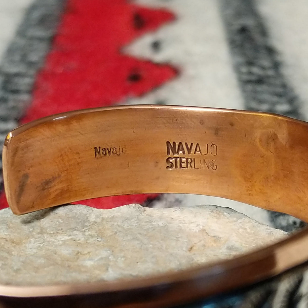 Copper and silver cuff by Robert Little featuring a repeating oxidized hand-stamped design across the silver center, framed by polished copper borders; artisan and Sterling Silver stamp.