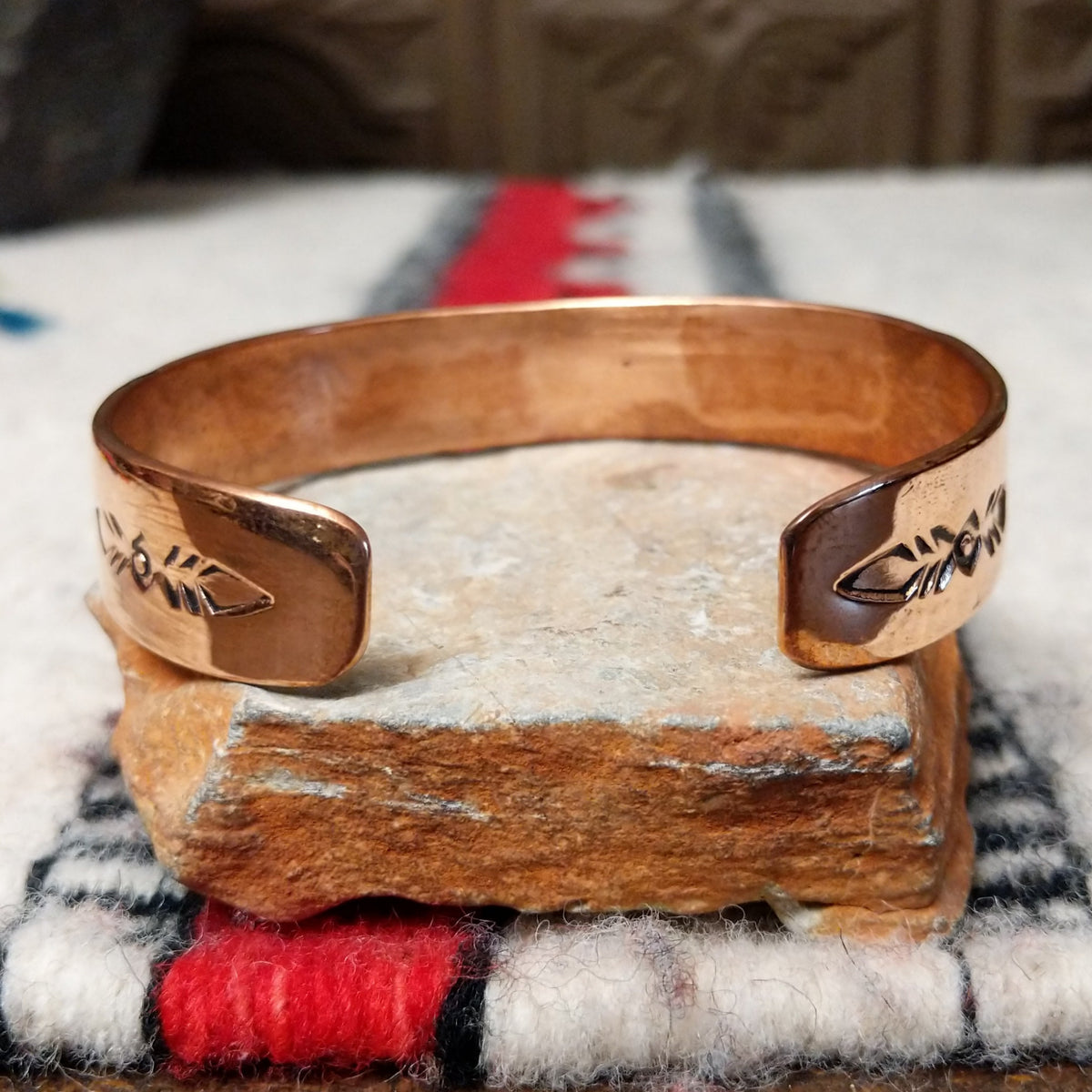 Copper and silver cuff by Robert Little featuring a repeating stepped geometric pattern in oxidized sterling silver, framed by polished copper borders; underside view.