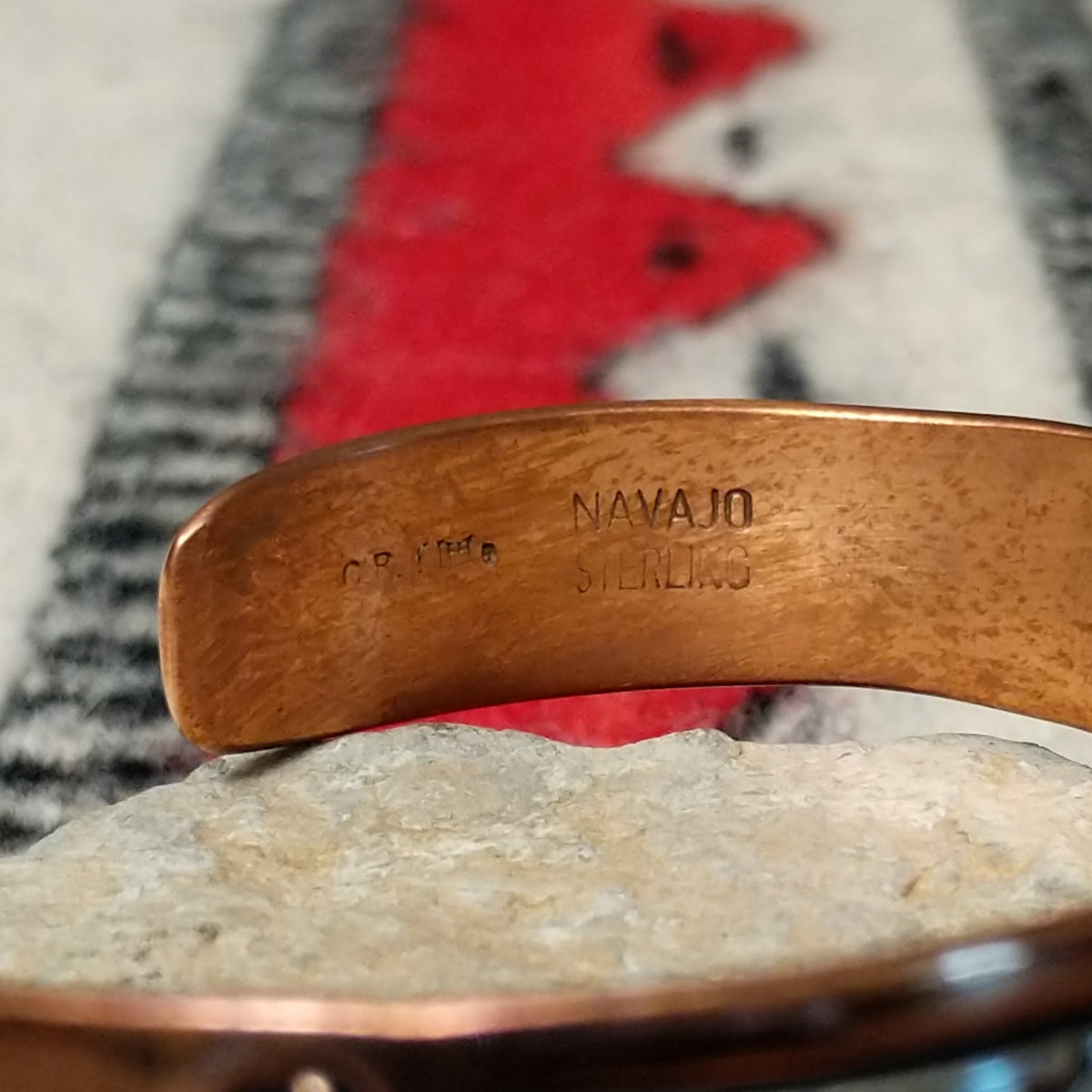 Copper and silver cuff by Robert Little featuring a repeating stepped geometric pattern in oxidized sterling silver, framed by polished copper borders; artisan and Sterling Silver stamp.