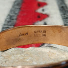 Copper and silver cuff by Robert Little featuring repeating stamped tipi-inspired geometric designs across an oxidized silver center, framed by polished copper borders; artisan and Sterling Silver stamp.