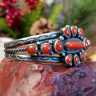 Sterling silver cuff with clusters of red coral, twisted rope accents, and scalloped stamps.
