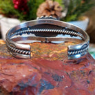 Sterling silver cuff with clusters of red coral, twisted rope accents, and scalloped stamps.
