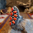 Sterling silver ring with coral set in clustered bezels, framed by intricate dot work.