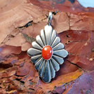 Sterling silver pendant with red coral centerpiece and diamond-shaped setting.