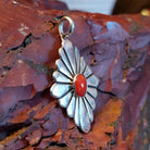 Sterling silver pendant with red coral centerpiece and diamond-shaped setting.