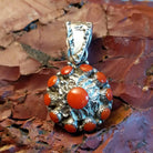 Sterling silver flower pendant with coral set in notched bezels and hammered finish.