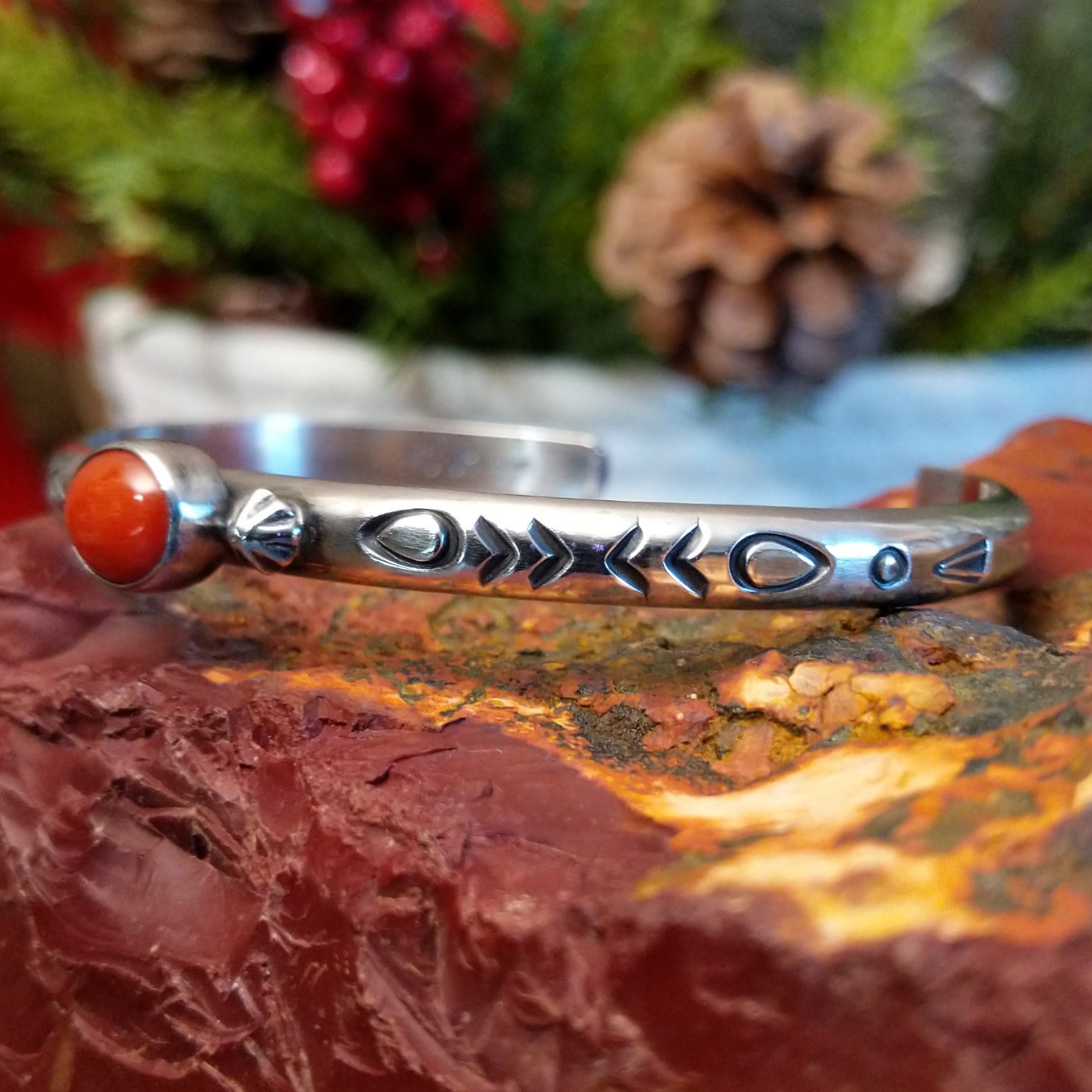 Sterling silver cuff with stamped designs and petite oval coral set in the bezel.