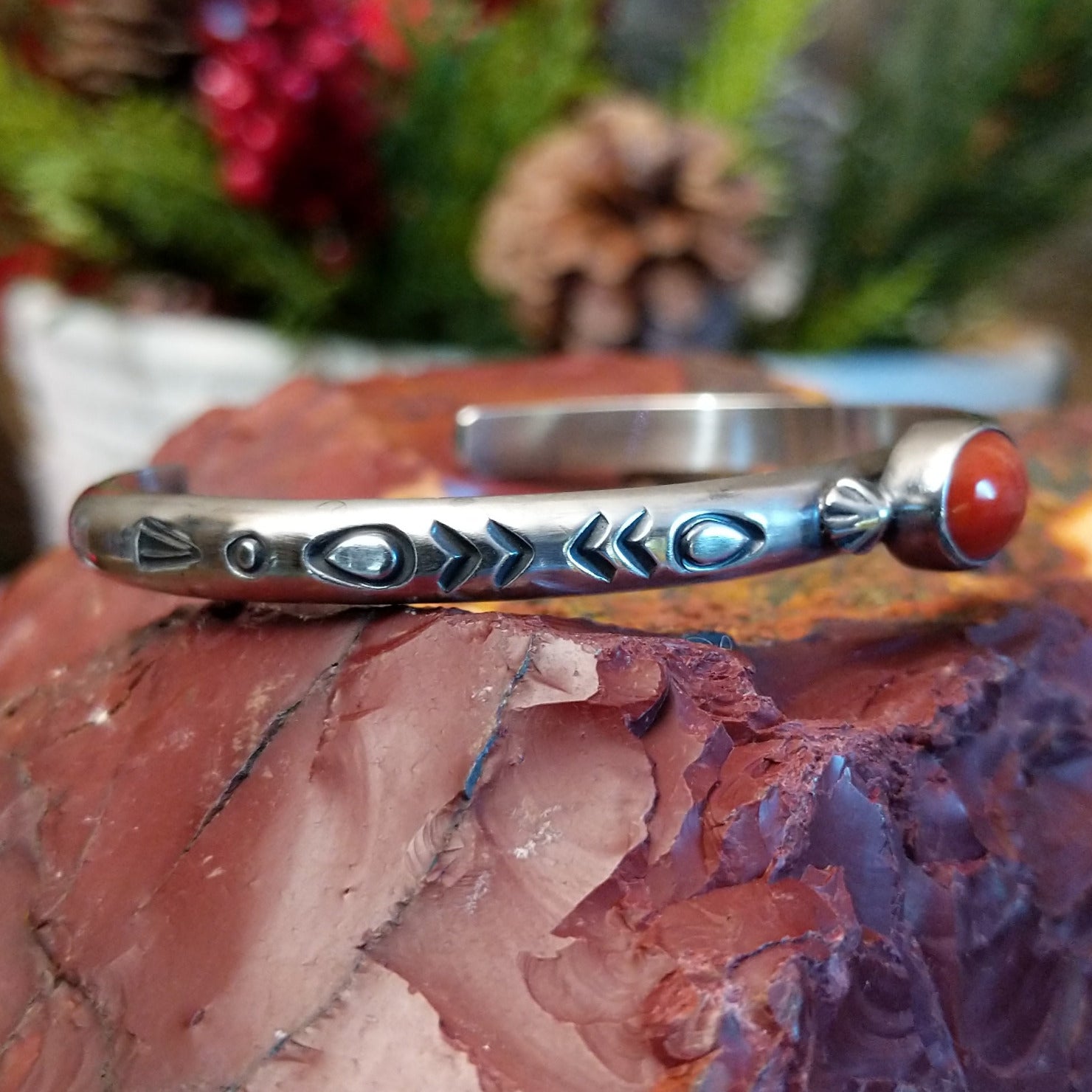 Sterling silver cuff with stamped designs and petite oval coral set in the bezel.