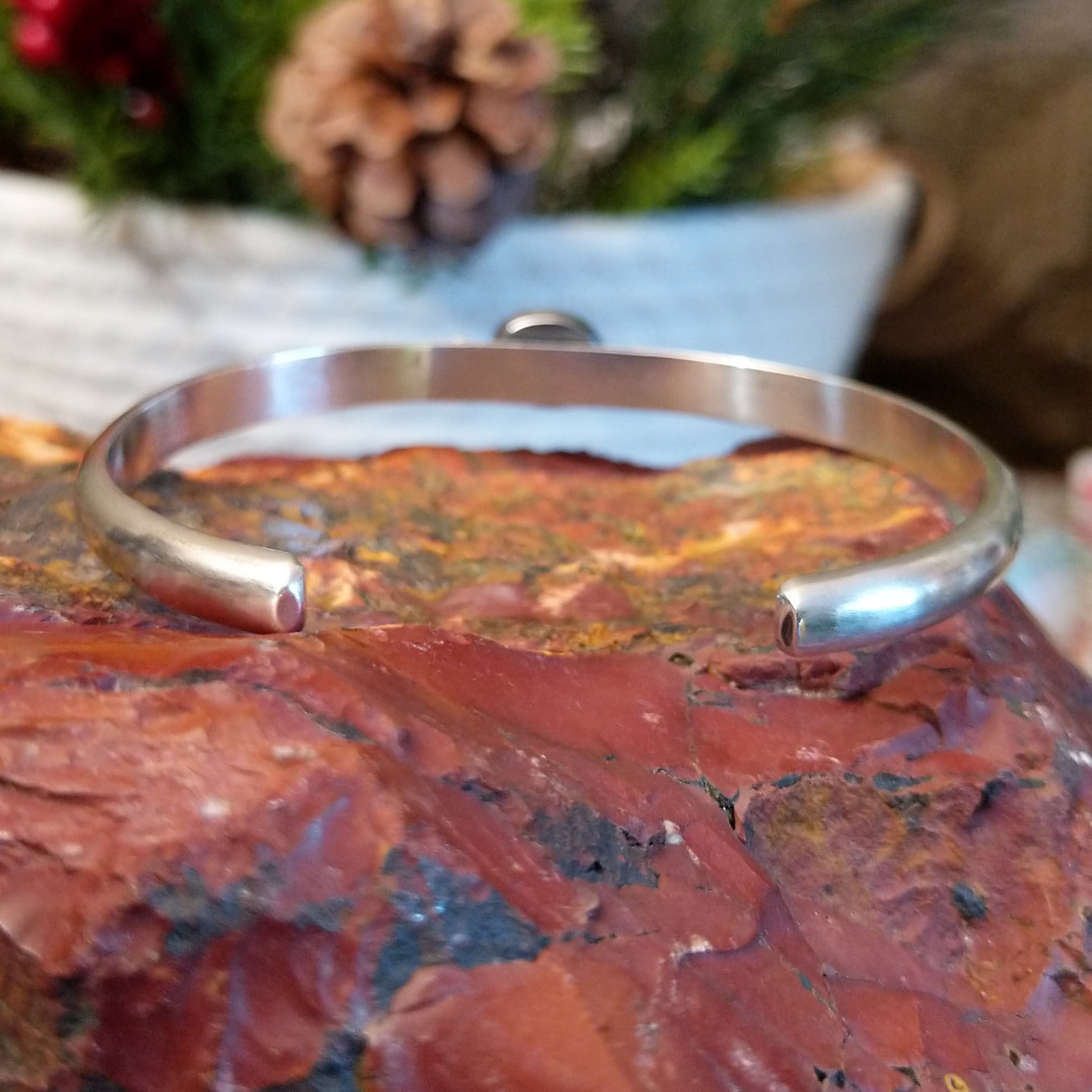 Sterling silver cuff with stamped designs and petite oval coral set in the bezel.