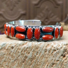 Sterling silver cuff bracelet with coral set in a parquet of oval bezels along the surface of the band.