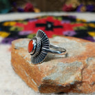 Striking Coral Ray Ring by Raymond Coriz featuring an oval red-orange coral stone framed by twisted sterling silver rope and radiating oxidized silver sunburst details; side view.