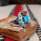 Coral and turquoise silver ring by Pauline Nelson with stamped motifs.