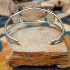 Handcrafted sterling silver cuff by Judy Wallace featuring a coral petitpoint concho centerpiece with matching side conchos, twisted rope detailing, silver bead accents, and a triple-shank cuff; underside view.