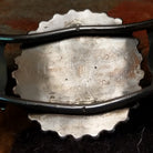 Handcrafted sterling silver cuff by Judy Wallace featuring a coral petitpoint concho centerpiece with matching side conchos, twisted rope detailing, silver bead accents, and a triple-shank cuff; artisan and tribe stamp.