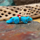 Cougar Zuni fetish by LaVies Natewa carved from turquoise with a medicine bundle on its back.