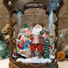 Cowboy Boot Santa Snow Globe featuring cowboy-style Santa with a child, presents, and a snowy evergreen inside a rustic brown Western boot decorated with silver stars and studs.