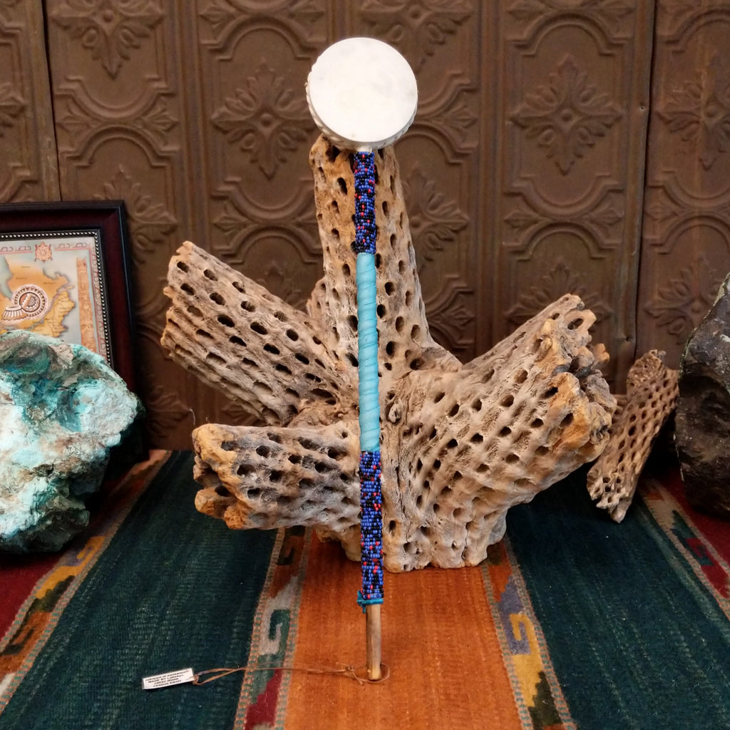 Beaded rattle with multicolored beads along the shaft and turquoise leather. 
