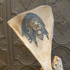 Deer shoulder blade engraved with headdress design.