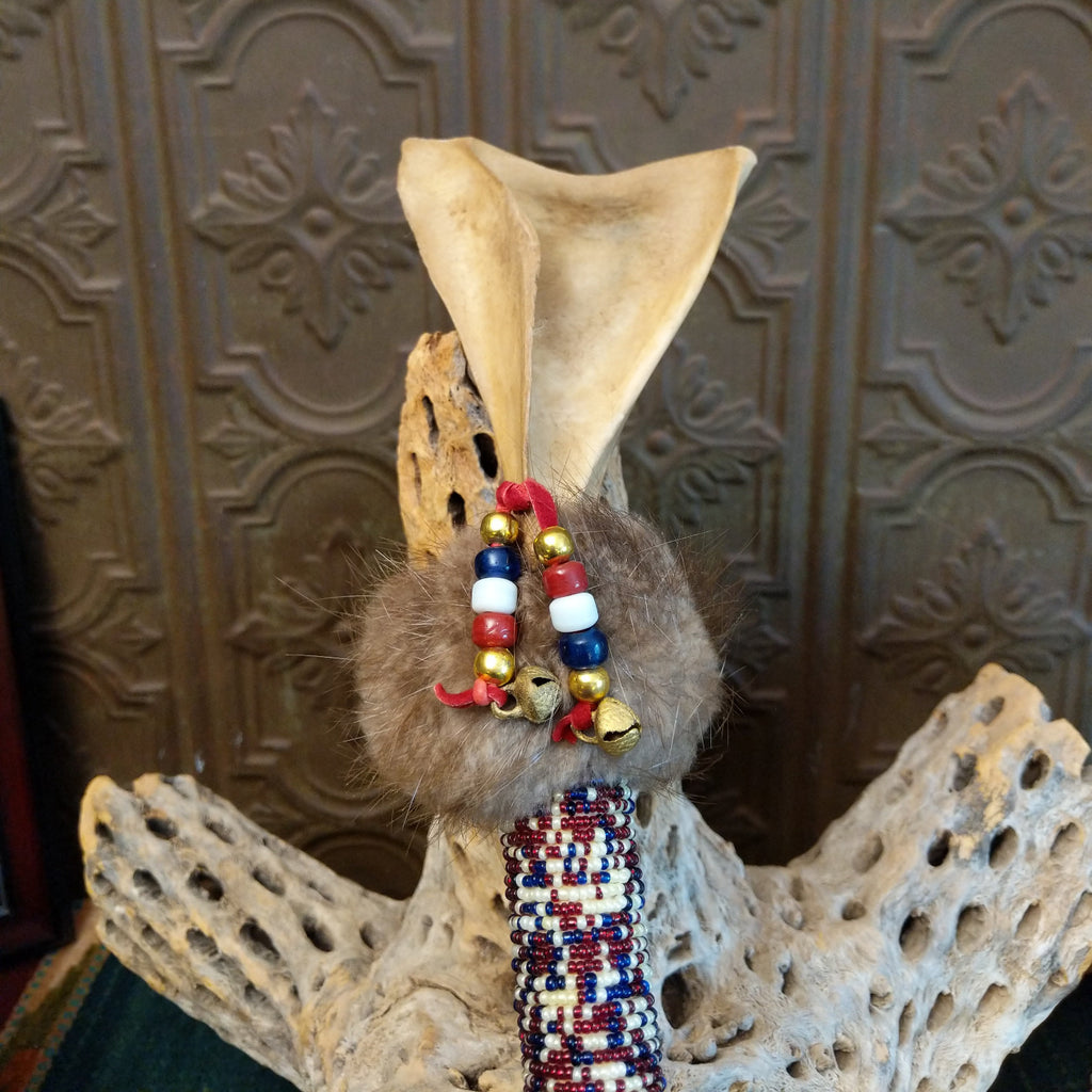 Beading, bells, and fur decorate the top of the shaft at a different angle.