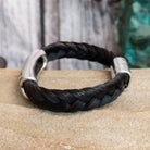 A braided black horsehair bracelet with an ornate crossed arrows accent and magnetic clasp.