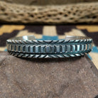Deep stamped sterling silver cuff by Jerrold Tahe, featuring bold hand-stamped patterns with deep texture on a handcrafted open sterling silver cuff.