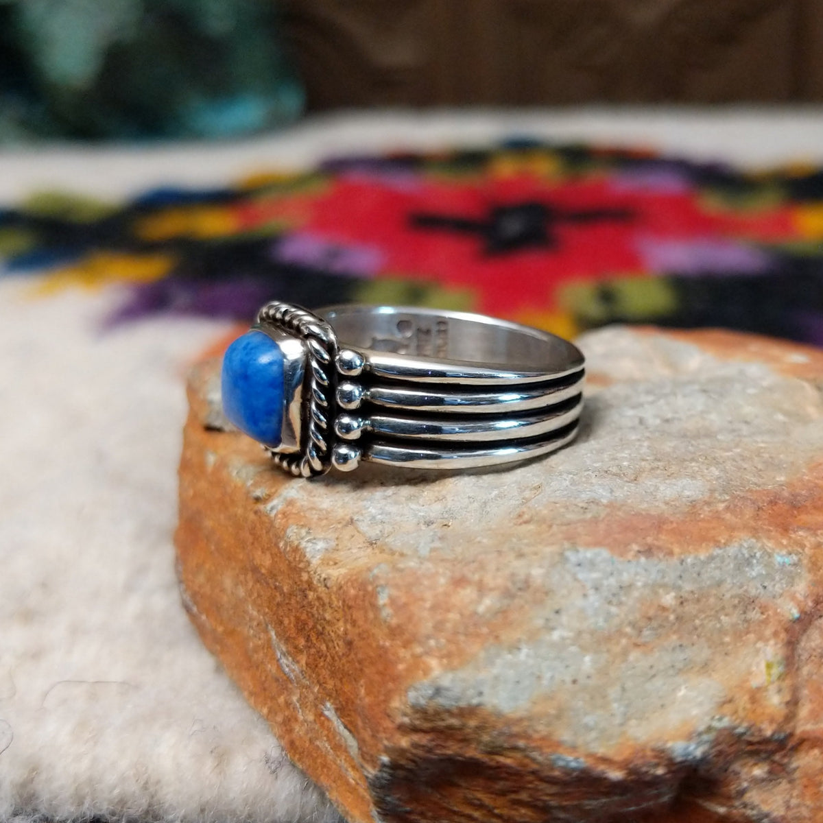 Denim lapis ring by Raymond Coriz with square stone, twisted silver border, and four-row band.