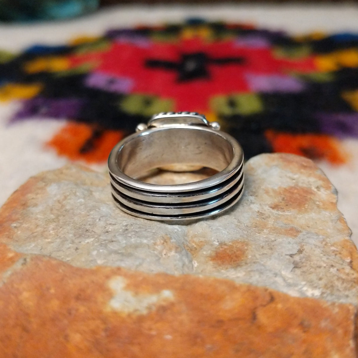 Denim lapis ring by Raymond Coriz with square stone, twisted silver border, and four-row band.