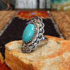 Nickel-free metal ring with a turquoise stone and ornate scalloped edge.
